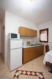 拉布Apartments and rooms by the sea Palit, Rab - 5044的厨房配有白色冰箱和微波炉