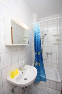 拉布Apartments and rooms by the sea Palit, Rab - 5044的浴室设有水槽和蓝色的浴帘