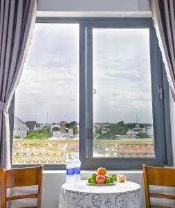 Hoi NghiaRuby Hotel - Tân Uyên - Bình Dương的窗前有果盘的桌子