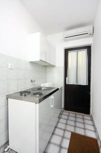 巴比诺波尔杰Apartments by the sea Sobra, Mljet - 4908的白色的厨房设有水槽和黑色的门