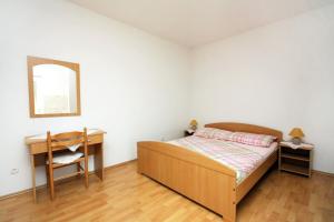马拉诺维奇Apartments by the sea Cove Saplunara, Mljet - 4896的一间卧室配有一张床、一张书桌和一面镜子