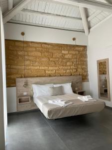 阿格里真托Oneira Rooms的一间卧室设有一张床和砖墙