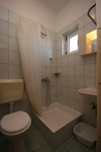 格拉达茨Apartments with a parking space Gradac, Makarska - 6724的带浴缸、卫生间和盥洗盆的浴室