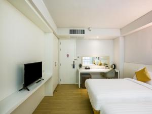 占那县Kitzio House Hotel Huai Kwang的一间卧室配有两张床、一张桌子和一台电视。
