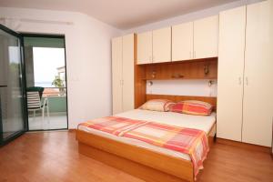 布雷拉Apartments with a parking space Brela, Makarska - 6907的一间卧室配有一张床和橱柜,并设有一个阳台