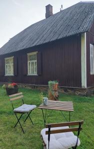 Jõevaara Veskitalu的野餐桌和两把椅子位于房子前面
