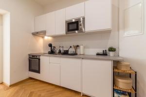 维也纳Vienna City Apartment的厨房配有白色橱柜和微波炉