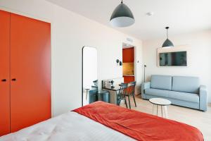 布鲁塞尔Appart'City Confort Bruxelles Centre Gare du Midi的一间卧室配有一张床、一张沙发和一张桌子
