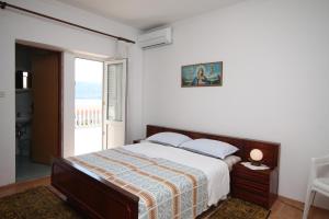 梅塔伊纳Apartments and rooms by the sea Metajna, Pag - 6496的一间卧室设有一张床和一个大窗户