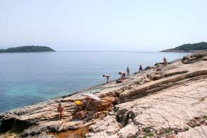 韦伯斯卡Rooms by the sea Vrboska (Hvar) - 4600的一群人,在岩石海岸