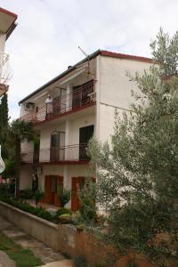 斯塔利格拉德-帕克利尼卡Apartments by the sea Starigrad, Paklenica - 6579的站在阳台上的人的建筑物