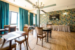 卡兹贝吉Hotel GENI Kazbegi的一间带桌椅和电视的用餐室