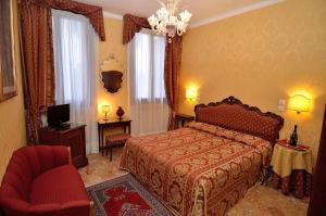 威尼斯布鲁诺酒店的一间卧室配有一张床、一把椅子和电视