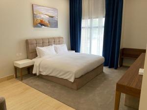 半月湾Half Moon Al Khobar Resort的一间卧室设有一张大床和一个窗户。