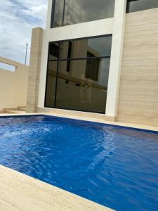 半月湾Half Moon Al Khobar Resort的房屋前有游泳池的房子
