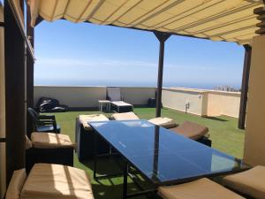贝纳尔马德纳Ático duplex en Benalmádena vistas al mar y montaña dos habitaciones的海景阳台上的玻璃桌