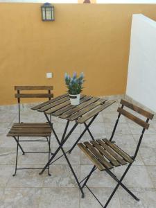 阿尔坎塔里利亚Casa do Pátio em Alcantarilha - Algarve的一张带两个长凳和盆栽的野餐桌