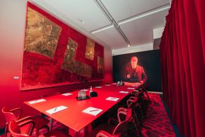 赫尔辛基Hotel AX的红色的房间,配有长桌子和红色椅子