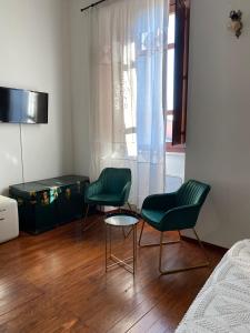 卡布拉斯Dimora Ferraris的卧室里设有两张绿色椅子和一张桌子