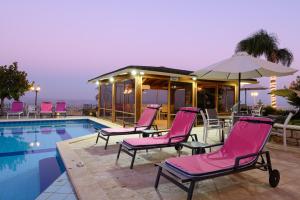 罗什平纳罗姆大厦酒店的一组游泳池畔的粉红色椅子