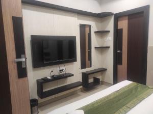 古瓦哈提Hotel Rudraksh- Near VIP Airport Guwahati的墙上配有平面电视的房间