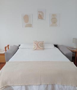 坎加斯德穆拉索Pura Playa - Rías Baixas - Galicia的一张带白色床单的床和一张沙发