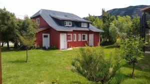 厄尔查尔坦安妮塔之家山林小屋的绿色草坪庭院中的红色房子