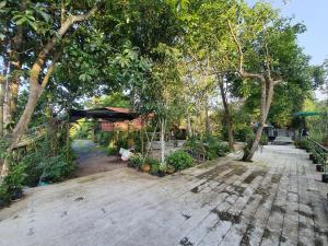 Ban Pak NamBaan Thabthong Homestay (บ้านทับทอง โฮมสเตย์)的种有树木和步行道的花园