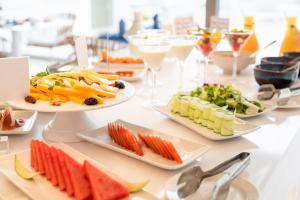 卡列罗港Royal Marina Suites Boutique Hotel的餐桌,带食物盘和酒杯