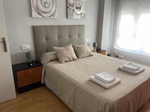 希洪Arena Playa Gijón by Flowhome的一间卧室配有一张大床和两条毛巾
