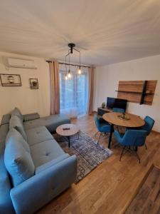 索科矿泉村Nina Apartman 2的客厅配有蓝色的沙发和桌子