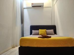 山打根ezzahrahsyariahhomestay的一间卧室配有一张黄色毯子床