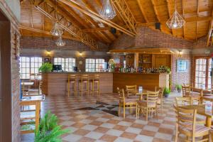 米娜克拉韦罗Colina del Valle的餐厅设有木制天花板和桌椅
