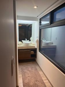 瓦哈卡市Zen Suites by Regente的一间带两个盥洗盆和大镜子的浴室