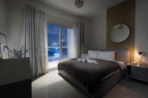 迪拜Unlock Metropolis Business Bay的一间卧室设有一张床和一个大窗户