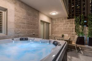 耶路撒冷Sea U Jerusalem Mahane Yehuda Apartment Hotel的配有桌椅的客房内的热水浴池