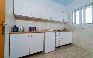 Megálon ChoríonMilios Studios的厨房配有白色橱柜和台面