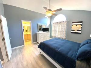 杰克逊维尔The Best Getaway Friends & Family Hangout!!!的一间卧室配有蓝色的床和吊扇