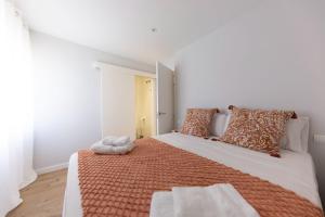 赫罗纳Bravissimo Eiximenis, with beautiful terrace and views的一间卧室配有一张带橙色和白色枕头的大床