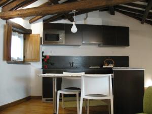 戈伊什Casa do Neveiro的厨房配有两把白色椅子和厨房岛