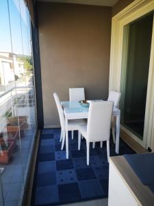 马里诺Delizioso appartamento nel cuore Castelli Romani的阳台上配有一张蓝色的桌子和白色的椅子