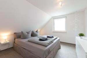 勒伯尔Apartment unter den Kiefern 93的白色卧室设有一张带窗户的床