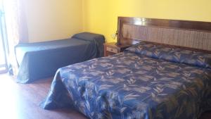 布里亚蒂科珊瑚蓝住宿加早餐旅馆的一间卧室配有一张带蓝色棉被的床