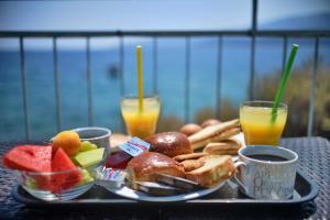 劳特拉奥雷亚斯埃利尼斯Hotel Kakanakos的托盘早餐食品,包括两杯橙汁
