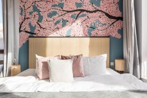 波兹南索雷城精品酒店的卧室配有一张墙壁上粉红色鲜花的床。