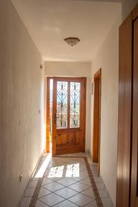 DutovljeApartma Na skdnu的走廊设有木门,铺有瓷砖地板