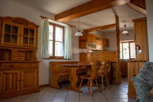 DutovljeApartma Na skdnu的厨房配有木制橱柜和桌椅