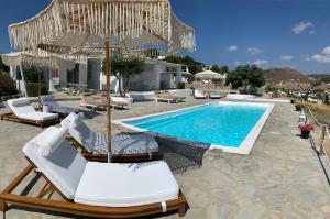 帕罗奇亚蓝海湾和里斯酒店的一个带躺椅和遮阳伞的游泳池