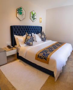 舍夫沙万VANCII Hotel的一间卧室配有一张大床和蓝色床头板