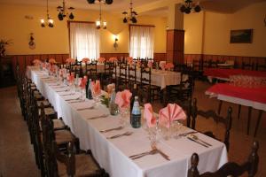圣米凯莱亚拉迪杰坎塔利昂酒店的一张长桌,房间配有白色的桌子和椅子